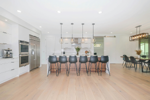 A remodeled kitchen with island and hanging lights.