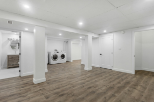 A brightly lit remodeled basement with bathroom and laundry area.